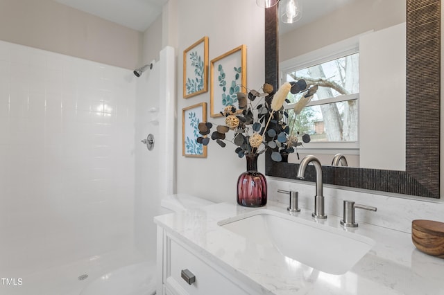 full bathroom featuring a tile shower and vanity