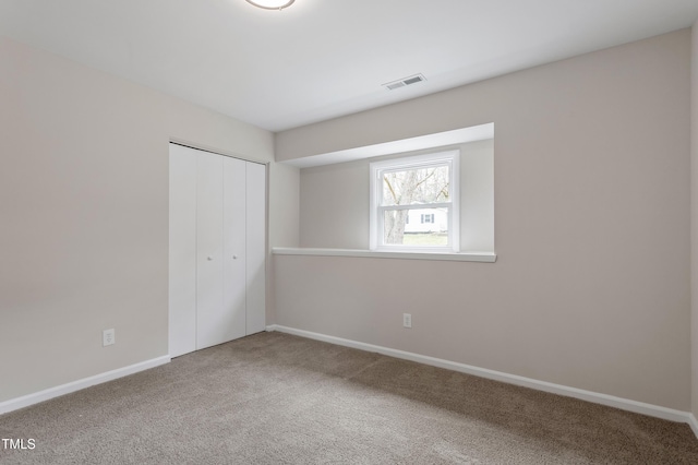 unfurnished bedroom with carpet, visible vents, a closet, and baseboards