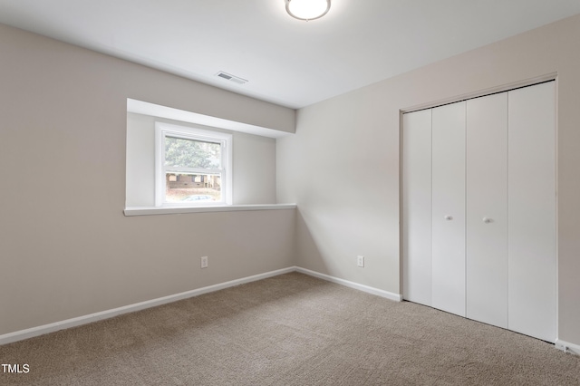 unfurnished bedroom featuring carpet flooring, baseboards, visible vents, and a closet