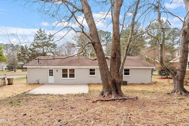 rear view of house featuring brick siding, cooling unit, and a patio