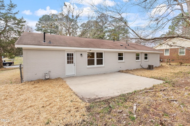 back of property with central air condition unit, fence, a patio area, and brick siding