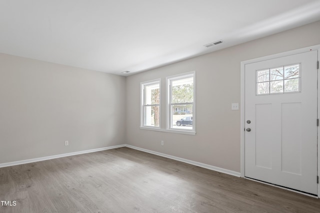 entryway with wood finished floors, visible vents, and baseboards