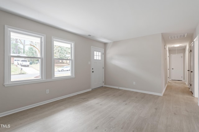 foyer entrance with visible vents, light wood-style flooring, and baseboards