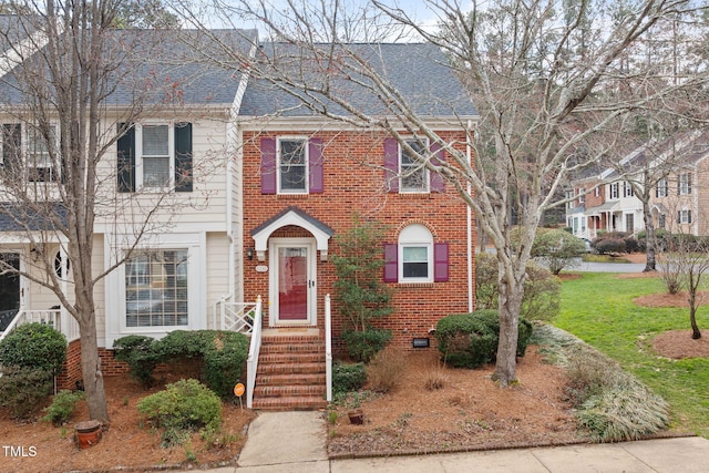 view of front of house with brick siding and a shingled roof