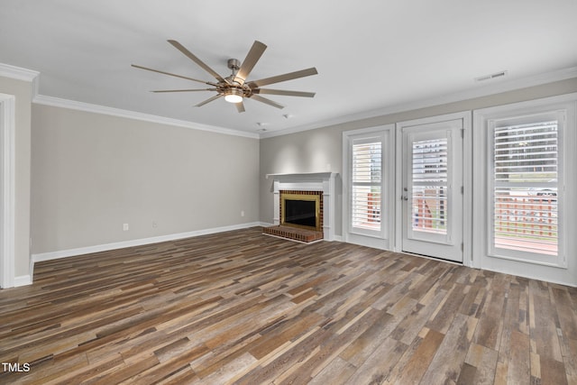 unfurnished living room with visible vents, wood finished floors, a fireplace, and ornamental molding