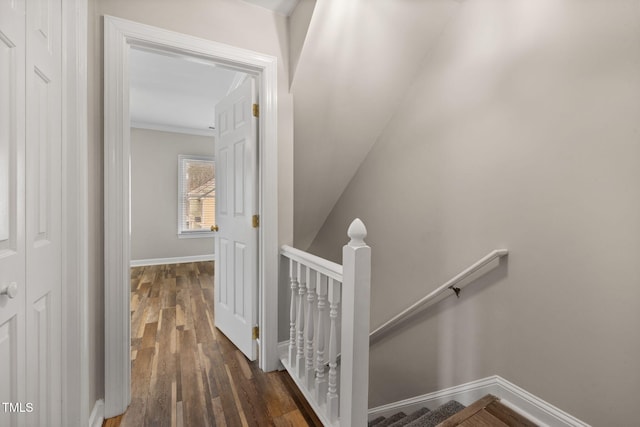 corridor with an upstairs landing, crown molding, baseboards, and wood finished floors