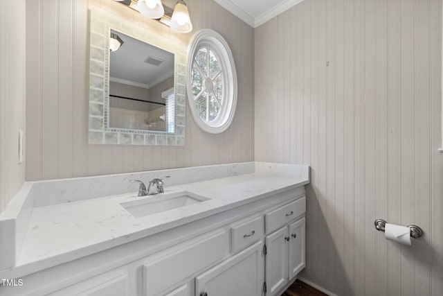 bathroom featuring vanity, a shower, visible vents, and ornamental molding