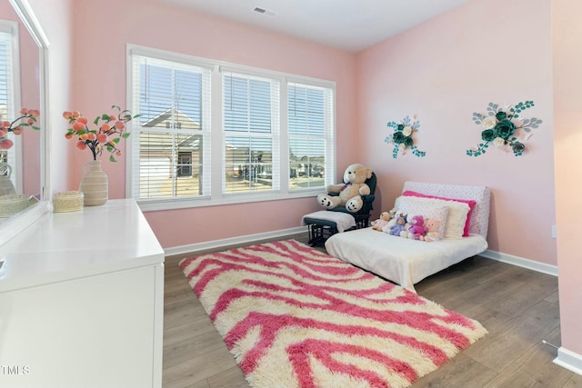 living area with visible vents, light wood-style flooring, and baseboards