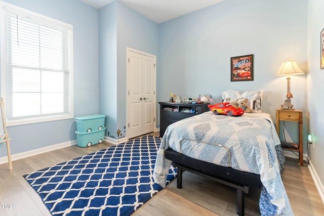 bedroom with baseboards and wood finished floors