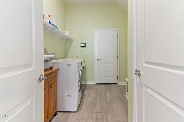 clothes washing area featuring washer and dryer, cabinet space, and baseboards