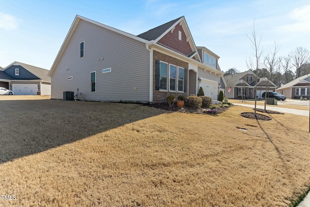 view of property exterior with central air condition unit, a lawn, a garage, and stone siding