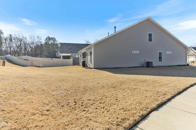 rear view of house featuring cooling unit and fence