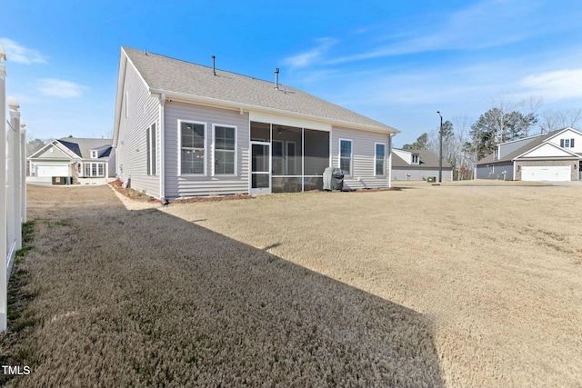 back of house with a sunroom and roof with shingles