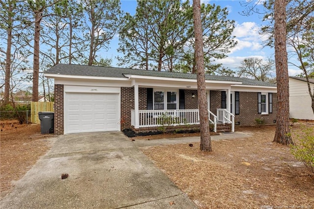 ranch-style house with a porch, fence, concrete driveway, an attached garage, and brick siding