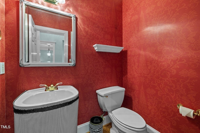 bathroom with toilet and wallpapered walls