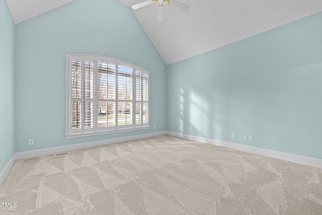 carpeted empty room featuring ceiling fan, high vaulted ceiling, and baseboards