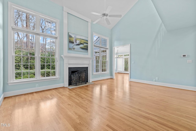 unfurnished living room featuring visible vents, high vaulted ceiling, light wood-style flooring, and a fireplace