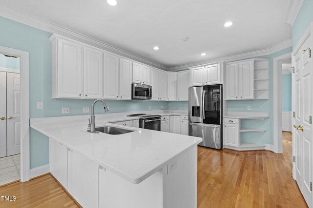 kitchen with a peninsula, open shelves, a sink, light countertops, and appliances with stainless steel finishes