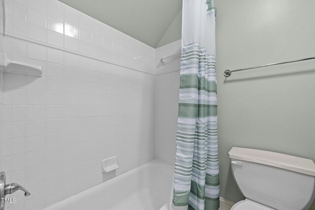 full bath featuring shower / bath combination with curtain, toilet, and vaulted ceiling