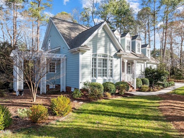 view of side of home with a yard, a shingled roof, and a pergola