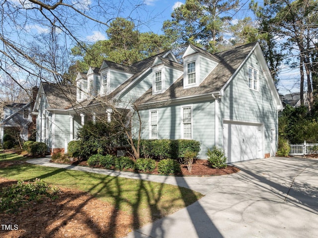 cape cod home featuring fence, a garage, driveway, and roof with shingles