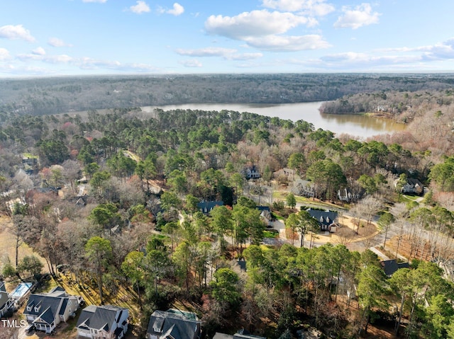 birds eye view of property with a view of trees and a water view