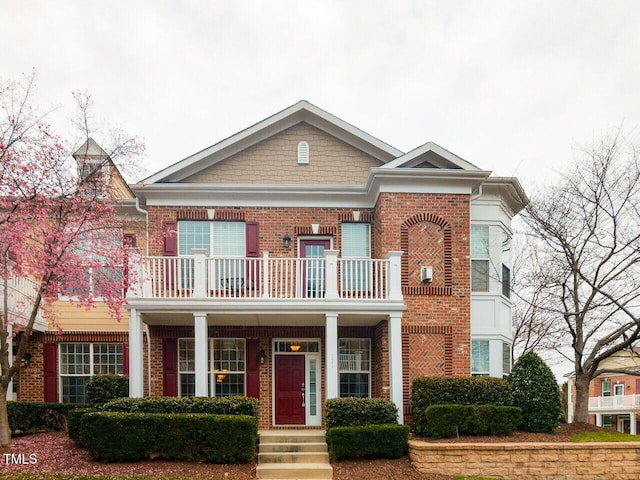 view of front facade featuring a balcony and brick siding