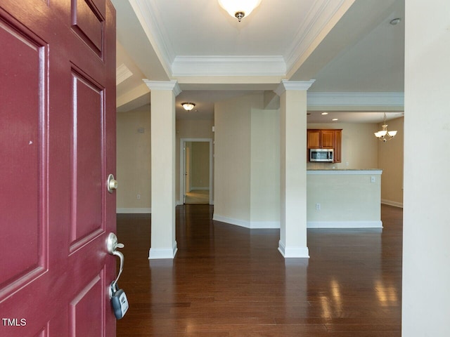 entryway featuring crown molding, decorative columns, baseboards, and dark wood-style flooring