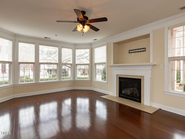 unfurnished living room featuring visible vents, baseboards, dark wood finished floors, a fireplace with flush hearth, and ornamental molding