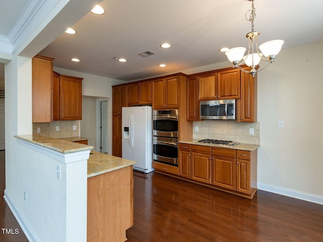 kitchen with light stone countertops, dark wood-style floors, visible vents, appliances with stainless steel finishes, and brown cabinets