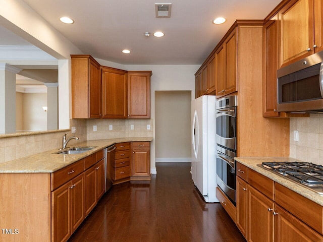 kitchen with visible vents, brown cabinets, a sink, light stone counters, and stainless steel appliances