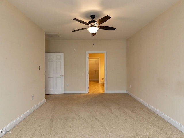 carpeted spare room with baseboards and a ceiling fan