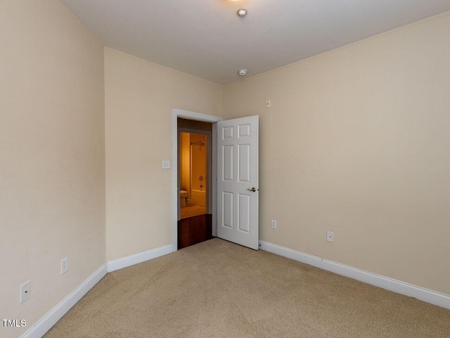 empty room with baseboards and light colored carpet