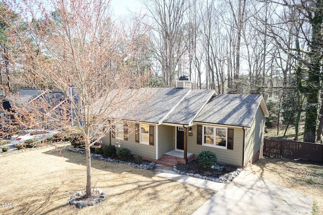 ranch-style house featuring a shingled roof, a chimney, and fence