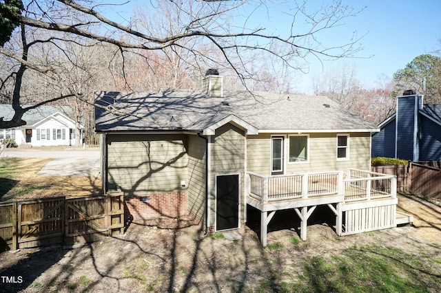 back of house with a shingled roof, fence, a wooden deck, a chimney, and a gate