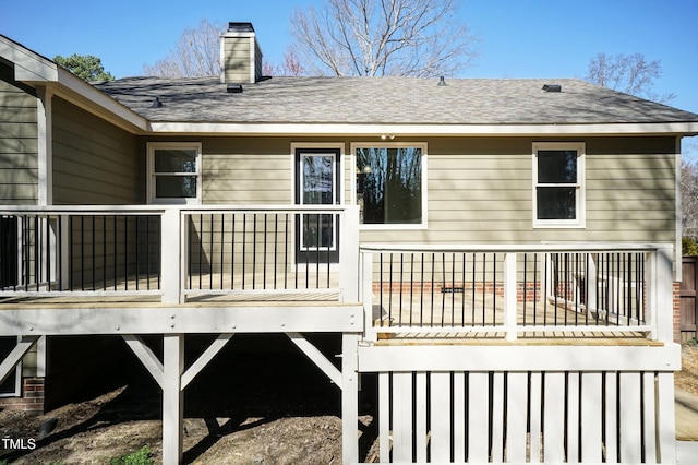 exterior space with a wooden deck and roof with shingles