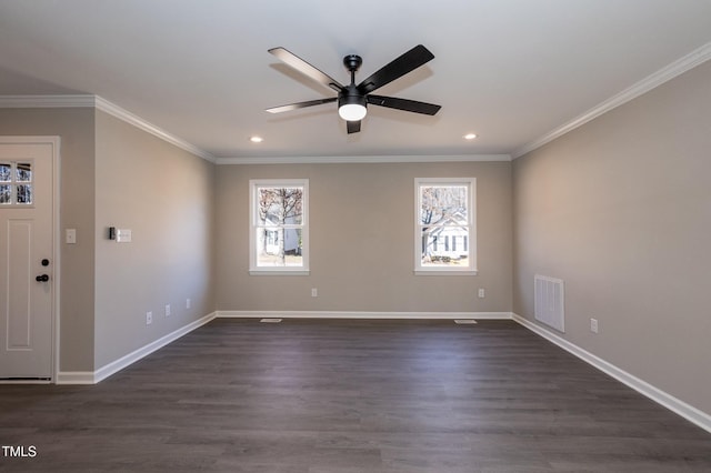 spare room featuring a ceiling fan, dark wood-style floors, visible vents, baseboards, and crown molding