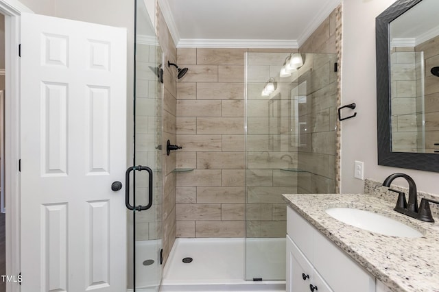 bathroom featuring a stall shower, ornamental molding, and vanity