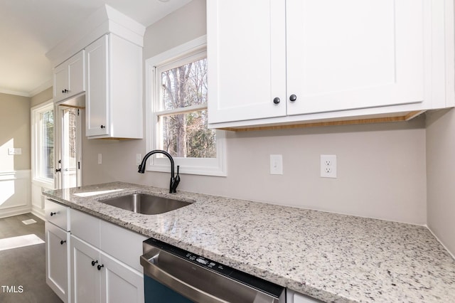 kitchen featuring dishwasher, white cabinets, light stone countertops, and a sink