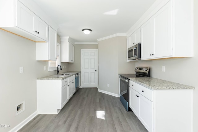 kitchen with white cabinets, light wood-type flooring, appliances with stainless steel finishes, and a sink