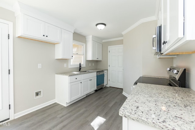 kitchen with baseboards, light wood-type flooring, stainless steel appliances, white cabinetry, and a sink