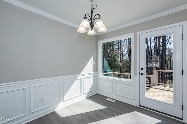 entryway with visible vents, a wainscoted wall, ornamental molding, dark wood-style floors, and a notable chandelier