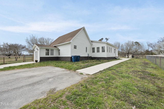 view of side of property featuring a yard, fence, driveway, and crawl space