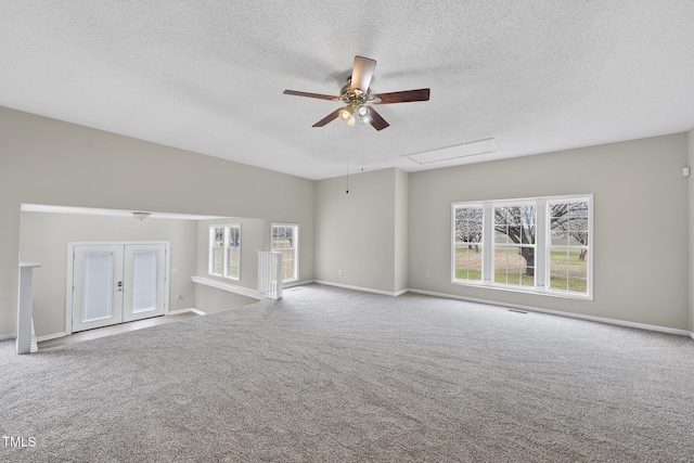 unfurnished living room featuring baseboards, attic access, ceiling fan, and carpet floors