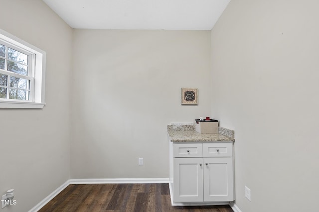 interior space with dark wood-type flooring and baseboards