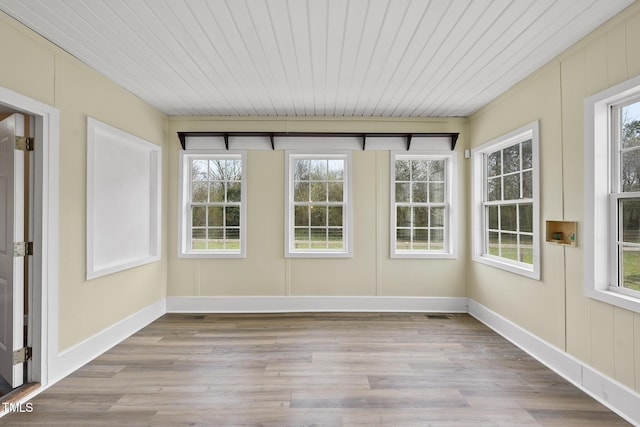 unfurnished sunroom featuring plenty of natural light and wooden ceiling