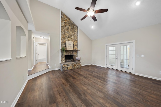 unfurnished living room featuring baseboards, ceiling fan, french doors, a fireplace, and wood finished floors