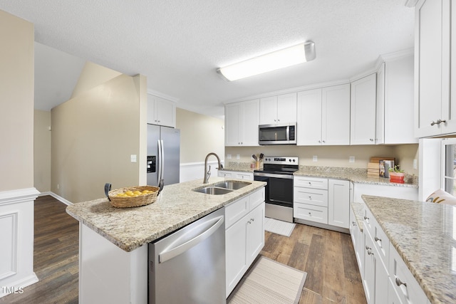 kitchen featuring a sink, stainless steel appliances, dark wood-style flooring, and white cabinetry