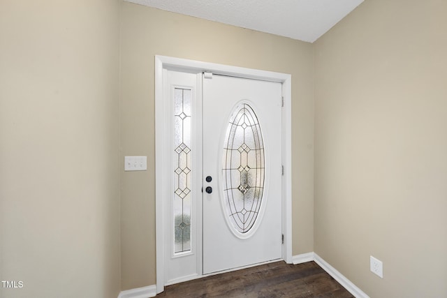 entryway featuring baseboards and dark wood-style floors