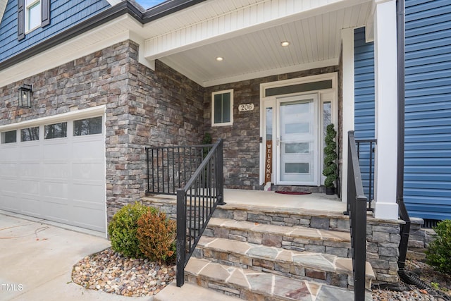 entrance to property with a garage, stone siding, a porch, and concrete driveway